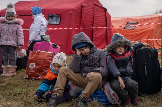 Ukrainians children sit after crossing the border from Ukraine to Budomierz, Poland. 03 March 2022. 
