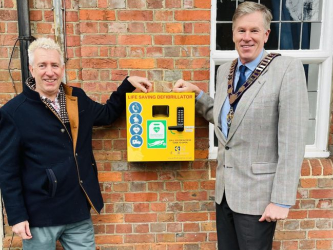 Haslemere Comrades Club head steward Mark Harris and town mayor Cllr Simon Dear unveil the new defibrillator
