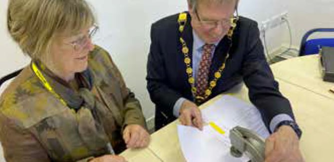 Anna Hocking and Petersfield town mayor Peter Clist use the Petersfield official seal, February 2023.