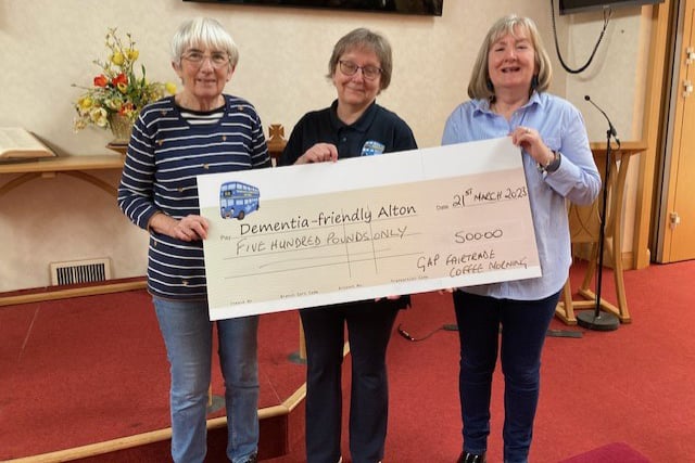 Karen Murrell of Dementia-friendly Alton is presented with a £500 cheque by Greater Alton Project coffee morning volunteers Christine Allan and Angela Scott, April 2023.
