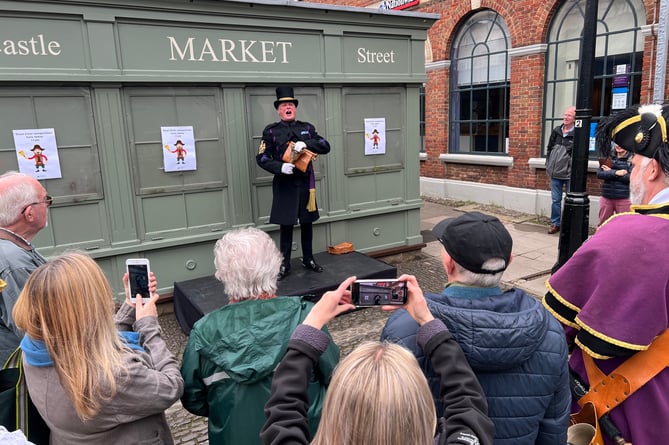Chair of the Ancient and Honourable Guild of Town Criers, and Haslemere town crier, Christian Ashdown addresses the crowd at the bottom of Castle Street, Farnham