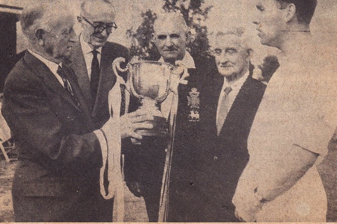 Thursley's 1972 I'Anson Cup-winning captain B Karn is handed the trophy by captain of the cup-winning team 50 years earlier, ML Rapley