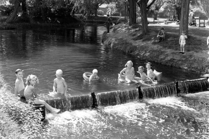 Children splashing around in the slightly deeper waters of Gostrey Meadow in 1957, created by the shallow weir across the river just upstream of the footbridge
