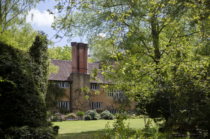 View of Munstead Wood house through the trees on the west lawn
