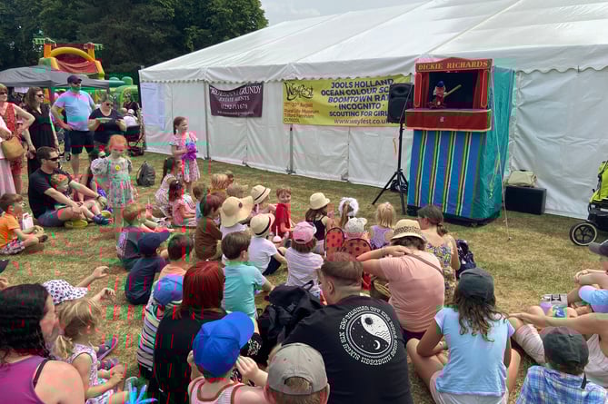 Children watch the Punch & Judy show at the 2023 Frensham Fayre