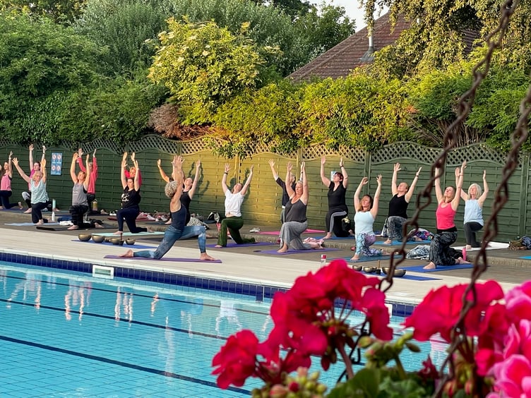 Yogis salute the sun at Petersfield Open Air Swimming Pool – sessions are run regularly by Wild Nest Yoga Studio