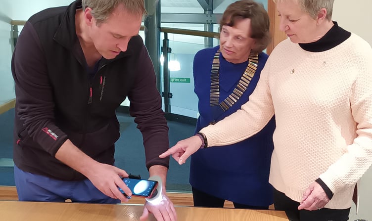 Dr Jules Barber demonstrates a dermatoscope to Alton Lions Club members Moira Baker, left, and Frances Parris, November 1st 2023.