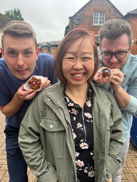 Luke Bateman and Elliott Williams tempt Chariya Khattiyot with their cornflake cakes, Market Square, Alton, December 2023.