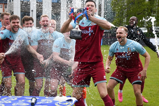 Farnham Town captain Ryan Kinnane lifts the Combined Counties Premier Division South title