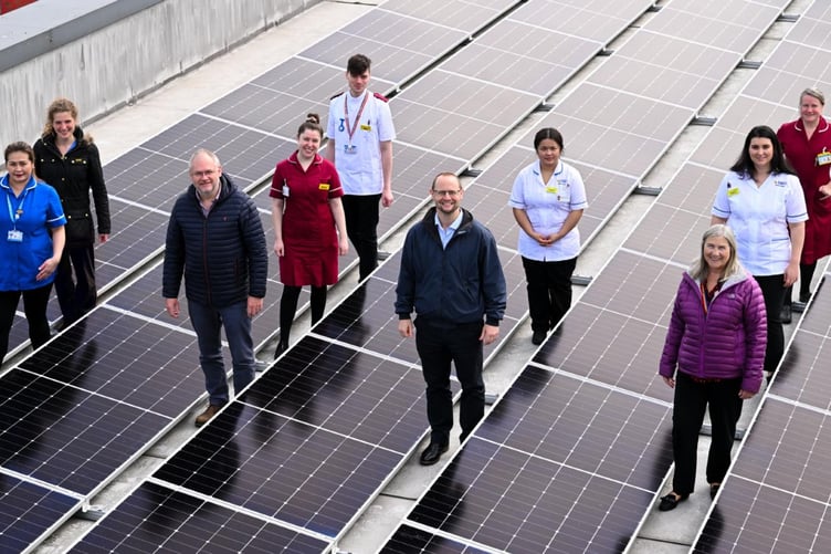 Members from the trust and hospital staff walk across the solar panels