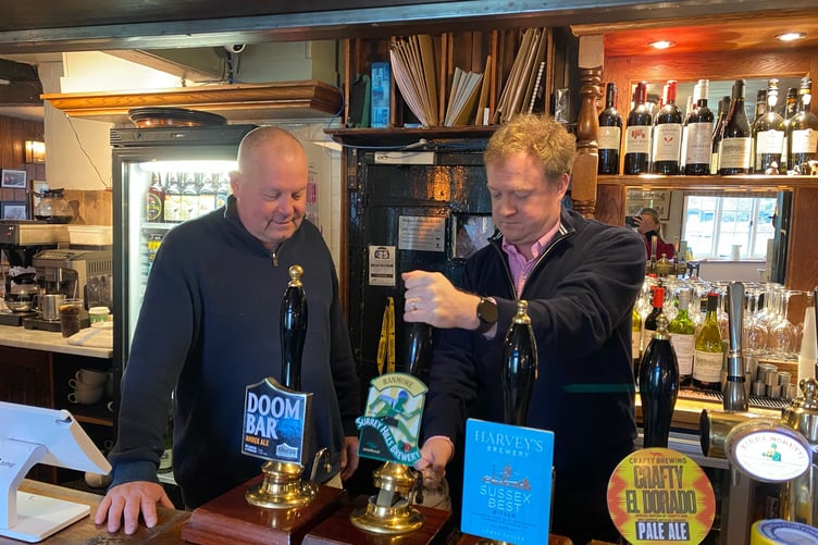 Greg Stafford MP pours a pint at the Barley Mow in Tilford