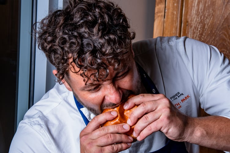 Adam enjoys one of his burgers.