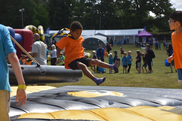 Beavers from Haslemere enjoying the inflatable obstacle course in the summer sunshine