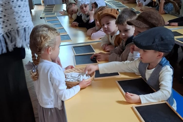 Badshot Lea School pupils take chalk to write on their slates.