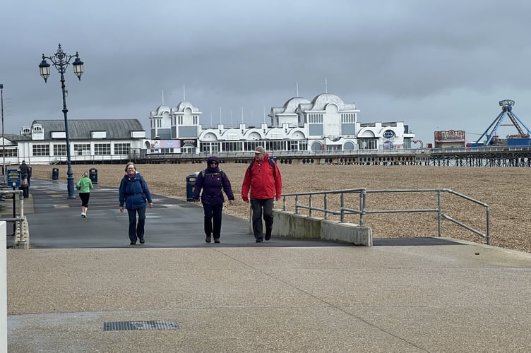 Braving the wind and waves along the Portsmouth seafront, the ramblers press on despite the stormy conditions.