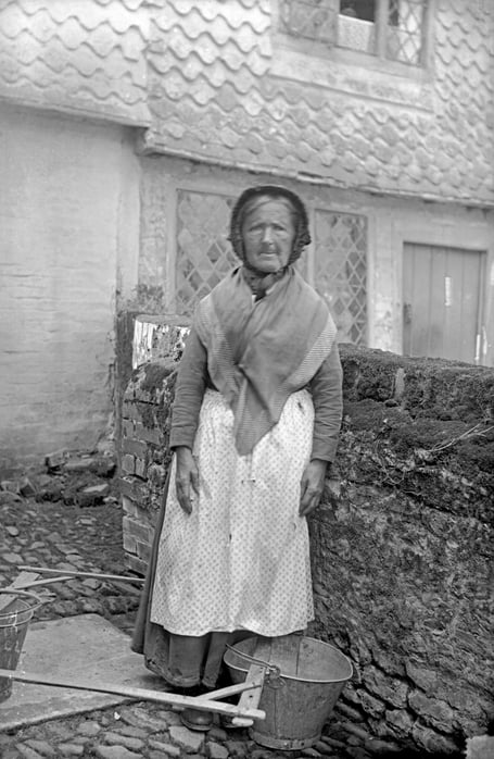 Haslemere water carrier Hannah Oakford, the last known public water carrier in the town, delivering pails of water to local households. Courtesy of Haslemere Museum.