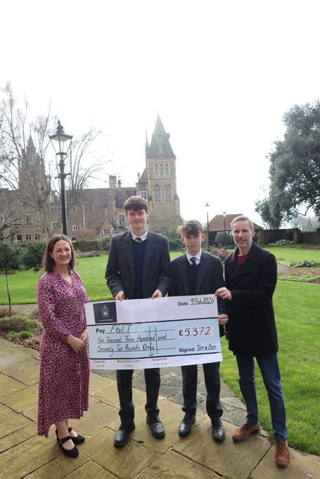 Tom and Ben present a cheque for more than £5,000 to F6IT Chair of Trustees George Sobek and interim CEO Anel Van de Merwe after completing their 60km charity run from Godalming to London. Credit: Charterhouse School