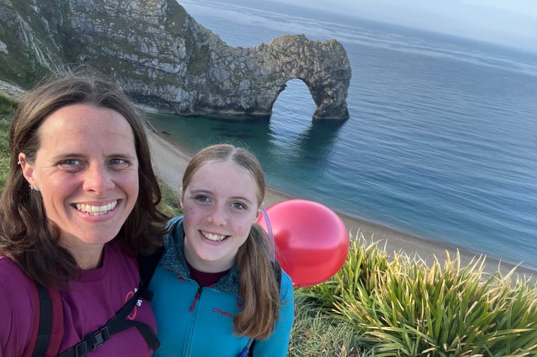 Eva Rondeau and her mother, Vicky, during the 30-mile Dorset coastal challenge in aid of Blood Cancer UK, with Durdle Door in the background.